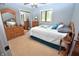 Cozy bedroom with neutral walls, carpet, and natural wood furniture with mirrored closet doors at 1000 Riverview Dr, Martinsville, IN 46151