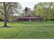 Brick home with a well-kept lawn, mature trees, and blooming flowers in the front yard at 1000 Riverview Dr, Martinsville, IN 46151
