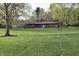 Charming brick home with a sprawling green lawn and mature trees in a serene setting at 1000 Riverview Dr, Martinsville, IN 46151