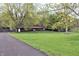 Charming single-story brick home with a lush green front yard and mature trees along the driveway at 1000 Riverview Dr, Martinsville, IN 46151