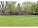 A beautiful single-story brick home with a well-manicured lawn and mature trees offering shade and curb appeal at 1000 Riverview Dr, Martinsville, IN 46151