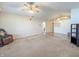 Inviting living room featuring neutral walls, a ceiling fan, and seamless flow into dining area at 10822 Cape Coral Ln, Indianapolis, IN 46229