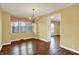 Dining room features a chandelier, hardwood floors, and natural lighting from the windows at 110 W Buckeye St, Cicero, IN 46034