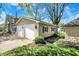 Exterior showcasing the home's additional garage space, lush lawn, and privacy landscaping at 110 W Buckeye St, Cicero, IN 46034