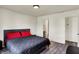 Bedroom showcasing wood floors, an upholstered bed with red pillows, and access to a bathroom at 11603 Presidio Dr, Indianapolis, IN 46235