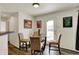Cozy dining area features a glass table and three upholstered chairs with access to the front entrance at 11603 Presidio Dr, Indianapolis, IN 46235