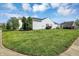 Spacious side yard featuring a lush green lawn, established trees, and manicured landscaping at 11603 Presidio Dr, Indianapolis, IN 46235