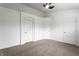 Spacious bedroom with carpet flooring, a ceiling fan, and three doors leading to closets and hallways at 11905 Kelso Dr # 3, Zionsville, IN 46077