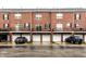 Townhome exterior featuring brick facade, personal balconies, and individual garages with white doors at 11905 Kelso Dr # 3, Zionsville, IN 46077