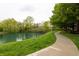 Picturesque pond with mature trees and walking path, enhancing the community's appeal at 11905 Kelso Dr # 3, Zionsville, IN 46077