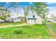 Backyard featuring a small house, green lawn, and a yellow flower garden, enhancing curb appeal at 1231 Nester St, Speedway, IN 46224