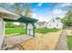 Backyard showcasing a concrete patio, green pergola, and chain-link fence, blending aesthetics with practical design at 1231 Nester St, Speedway, IN 46224