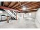 Spacious basement with concrete floors, exposed wood ceiling, laundry area, and stairs, ready for customization at 1231 Nester St, Speedway, IN 46224