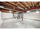 Large unfinished basement with concrete floors, exposed beams, and staircase, offering ample potential for renovation at 1231 Nester St, Speedway, IN 46224