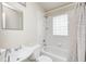 Well-lit bathroom with a white tiled shower-tub and glass block window at 1231 Nester St, Speedway, IN 46224