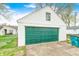 View of the detached garage featuring a green garage door and white siding at 1231 Nester St, Speedway, IN 46224