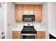 Close up of modern kitchen with stainless appliances, light countertops, and wood cabinets at 1231 Nester St, Speedway, IN 46224