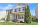 This two-story home features an inviting front porch, attached garage, and fresh landscaping at 12704 Bearsdale Dr, Indianapolis, IN 46235