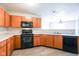 Open kitchen boasts wooden cabinets and black appliances, creating a warm, functional cooking space at 12704 Bearsdale Dr, Indianapolis, IN 46235