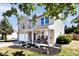 Side view of a two-story home showcasing a covered porch, landscaped garden, and classic architectural details at 12981 Coyote Run, Fishers, IN 46038