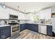 Well-appointed kitchen with white and navy cabinets, stainless steel appliances, and unique backsplash at 12981 Coyote Run, Fishers, IN 46038
