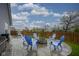 Backyard featuring a stone fire pit, blue Adirondack chairs, and a stainless-steel grill at 1299 W Crystal Dr, Fortville, IN 46040