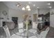 Dining area with hardwood floors, glass table, upholstered chairs, and a view into the living room at 1299 W Crystal Dr, Fortville, IN 46040