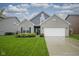 Charming home features a well-manicured lawn and attached two car garage at 1299 W Crystal Dr, Fortville, IN 46040