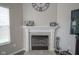 Close-up of the fireplace with white mantel, tiled surround, and a clock on the wall above at 1299 W Crystal Dr, Fortville, IN 46040
