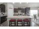 Kitchen island with red stools, granite countertops, and dark cabinets at 1299 W Crystal Dr, Fortville, IN 46040