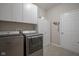 Laundry room features modern washer and dryer with overhead storage at 1299 W Crystal Dr, Fortville, IN 46040