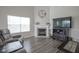 Bright living room with a fireplace, large window, wood floors, and a television with storage at 1299 W Crystal Dr, Fortville, IN 46040