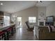Open-concept living room featuring hardwood floors, a vaulted ceiling, fireplace, and sliding glass door leading to the backyard at 1299 W Crystal Dr, Fortville, IN 46040