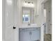 Modern bathroom featuring gray vanity, chrome fixtures, a mirror, and an open doorway to an adjacent room at 14349 Marsdale Pl, Carmel, IN 46074