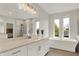 Bright bathroom with a large mirror, double windows, a soaking tub, and a separate shower at 14349 Marsdale Pl, Carmel, IN 46074
