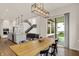 Bright dining room features a modern light fixture, a large wood table, and easy access to the outdoor area at 14349 Marsdale Pl, Carmel, IN 46074