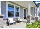 Inviting front porch with stone accents, offering a relaxing seating area and stylish black front door at 14349 Marsdale Pl, Carmel, IN 46074