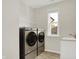 Well-equipped laundry room featuring modern washer and dryer, sink, and bright natural light at 14349 Marsdale Pl, Carmel, IN 46074