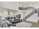 Open concept living room with kitchen, staircase with black railings, and large windows at 14349 Marsdale Pl, Carmel, IN 46074