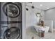 Modern bathroom with a glass shower, a washing machine and dryer, and a standalone bathtub at 1476 N Illinois St, Indianapolis, IN 46202