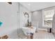 Spa-like bathroom featuring a glass-enclosed shower and freestanding tub under a window at 1476 N Illinois St, Indianapolis, IN 46202