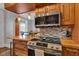 Modern kitchen with stainless steel microwave, stove, and breakfast bar showcasing wood cabinets at 1476 N Illinois St, Indianapolis, IN 46202
