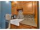 Well-appointed kitchen with stainless steel appliances, granite counters, tile backsplash, and farmhouse sink at 1476 N Illinois St, Indianapolis, IN 46202