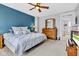Spacious bedroom with a ceiling fan, blue accent wall, and natural light at 1476 N Illinois St, Indianapolis, IN 46202