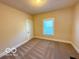 Neutral-toned bedroom featuring a window with blinds and a door at 1510 W 22Nd St, Indianapolis, IN 46202