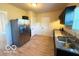 Bright kitchen featuring stainless steel refrigerator, granite countertops, and wood-look flooring at 1510 W 22Nd St, Indianapolis, IN 46202