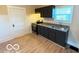 Well-lit kitchen featuring dark cabinetry, granite countertops, and wood-look flooring at 1510 W 22Nd St, Indianapolis, IN 46202