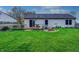 Spacious backyard with well-maintained grass, a deck, a fire pit, and a classic home exterior at 1910 Riverstone Ct, Westfield, IN 46074