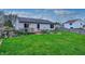 A well-maintained backyard with green grass, a wooden deck, a fire pit, and a wooden fence at 1910 Riverstone Ct, Westfield, IN 46074