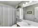 Bathroom featuring a sink, framed mirror, decorative shelves, and a striped shower curtain at 1910 Riverstone Ct, Westfield, IN 46074